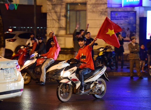Fan hâm mộ bóng đá Việt Nam vui mừng vẫy cờ trên đường phố 